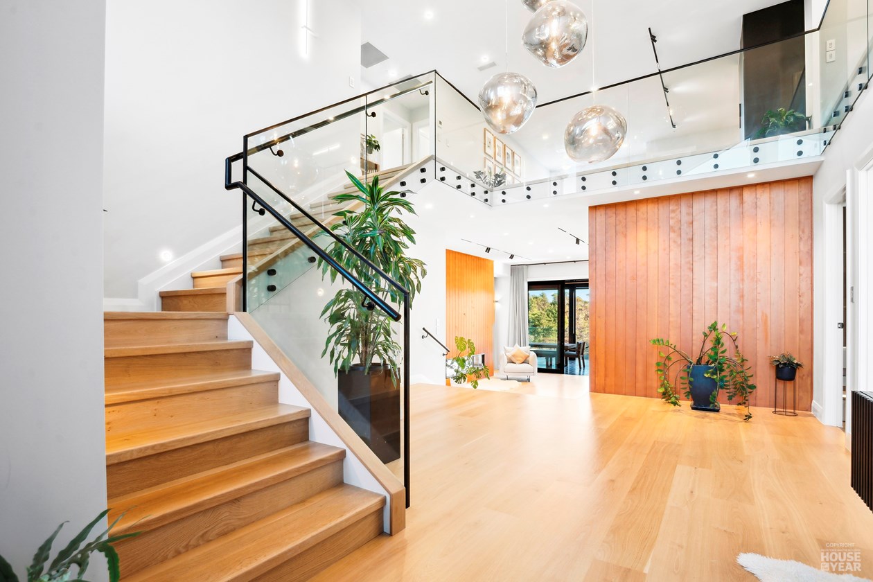 Entry staircase with glass balustrade and pendant lights