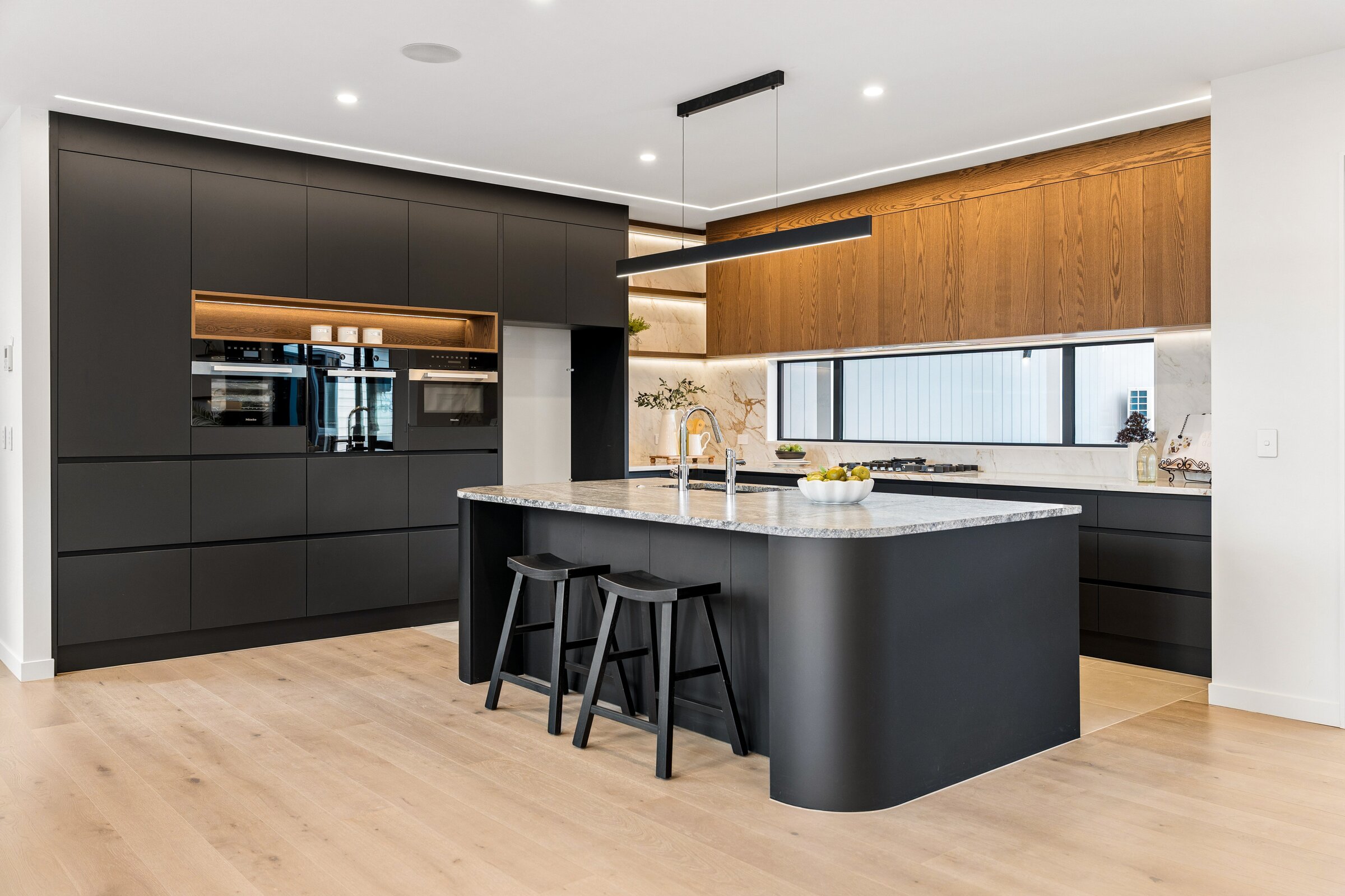 Kitchen with dark joinery and timber cabinetry at 73 Kewa Road